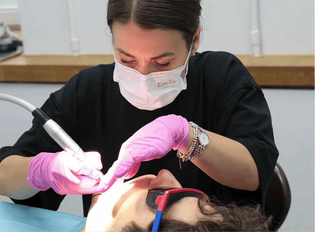 установка брекетов при скученности зубов — фиксация замка световой лампой